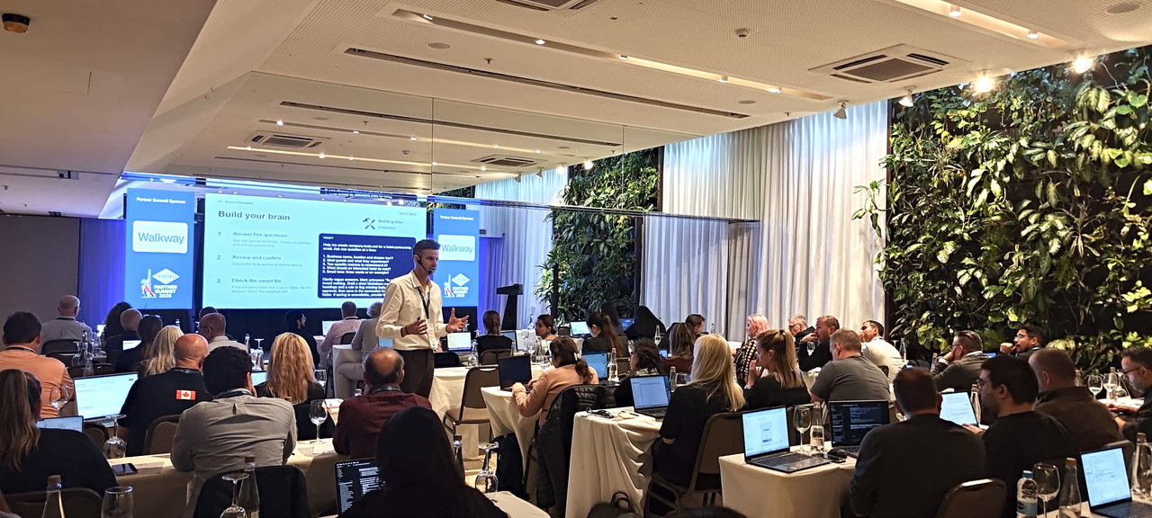 Oliver Green leading the interactive Build It In The Room workshop at the Gray Line Partner Summit, with a full room of attendees building on laptops